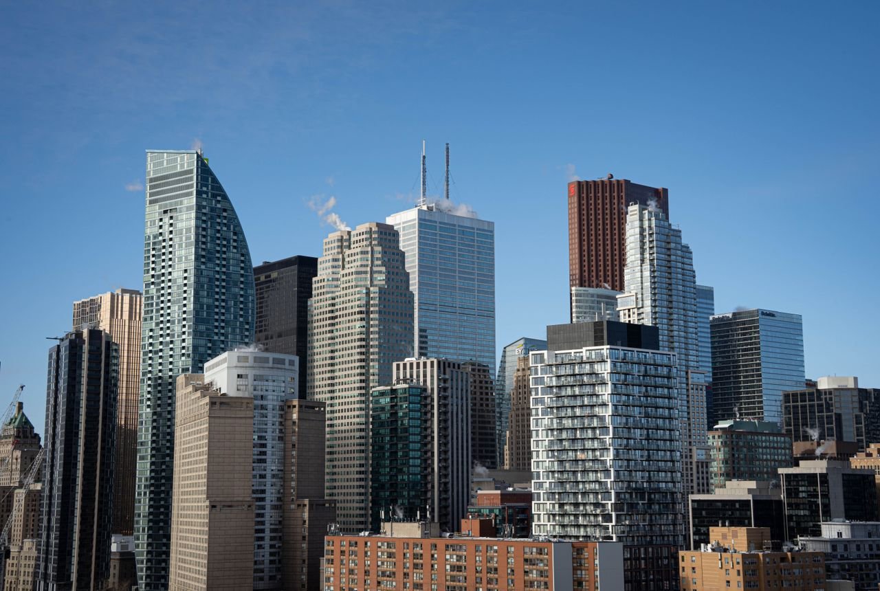 Aerial view of Torontos iconic skyline featuring modern skyscrapers under a clear blue sky.